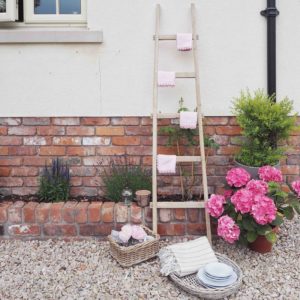 Wooden ladder with pink napkins and tableware