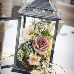 Lantern with fresh flowers on wedding table 
