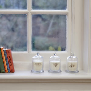 Three cloche candles on windowsill